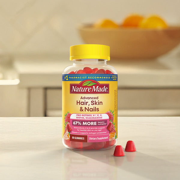 Nature Made Advanced Hair, Skin & Nails gummies bottle next to gummies on a counter