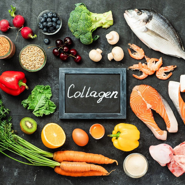 Assorted foods including vegetables, fruits, and protein sources arranged around a blackboard with 'Collagen' on a dark surface.