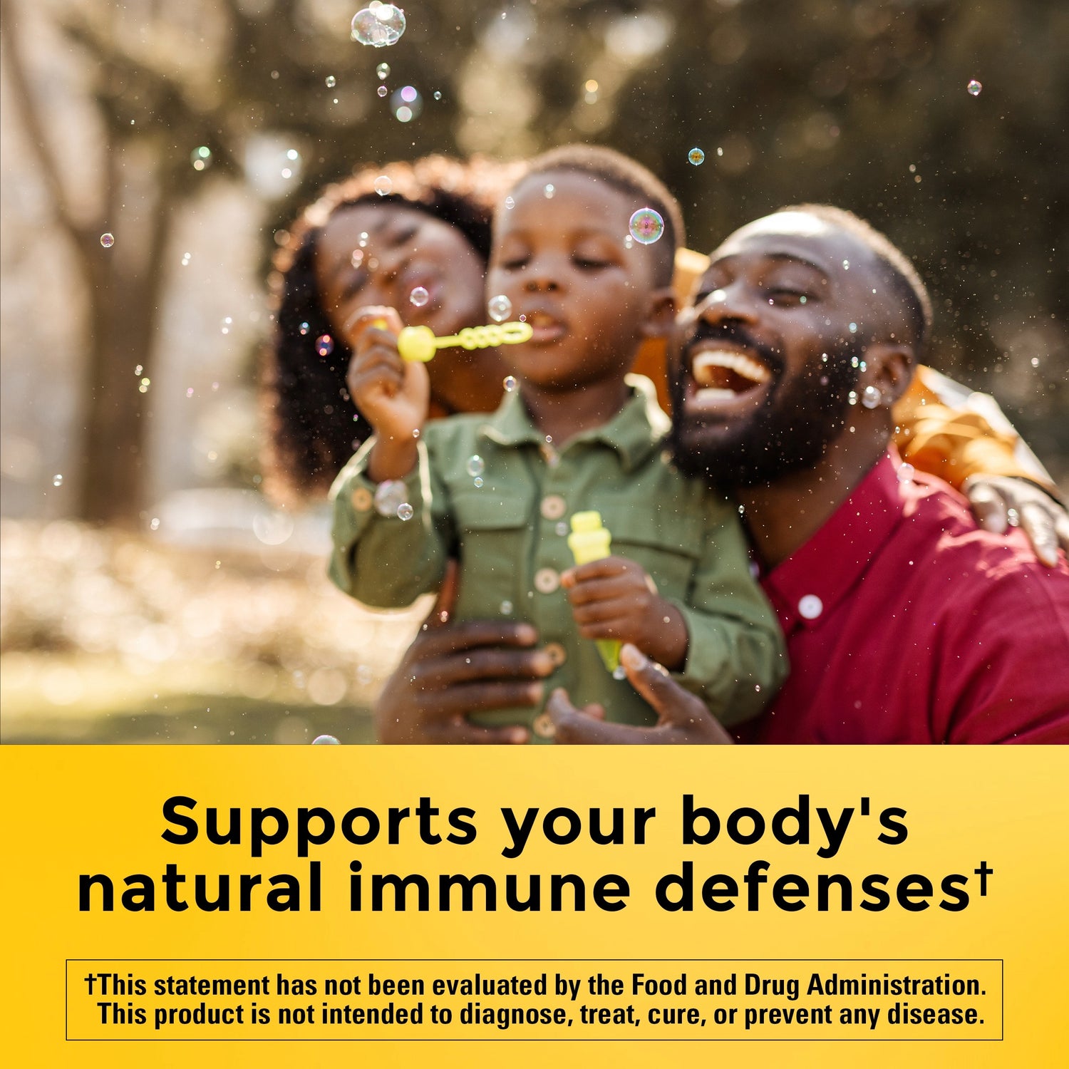 Vitamin E 1000 IU (450 mg) dl-Alpha Softgels | Family blowing bubbles outdoors with supports your body's natural immune defenses text on a yellow background.