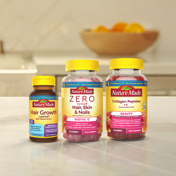 Nature Made Hair Growth Lustriva, Zero Sugar Hair, Skin & Nails gummies & Collagen Peptides + C gummies bottles on a kitchen counter.